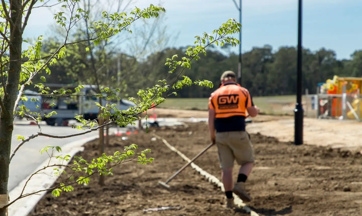 A photo of a Greater West Landscapes maintenance worker out doors in the field at work.