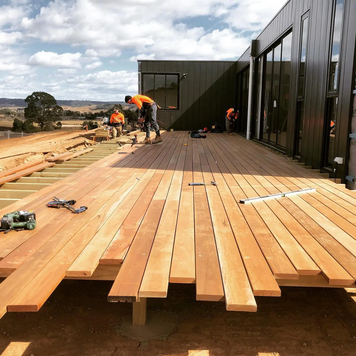 A photo of the deck being built by a team of Greater West Landscapes construction workers.