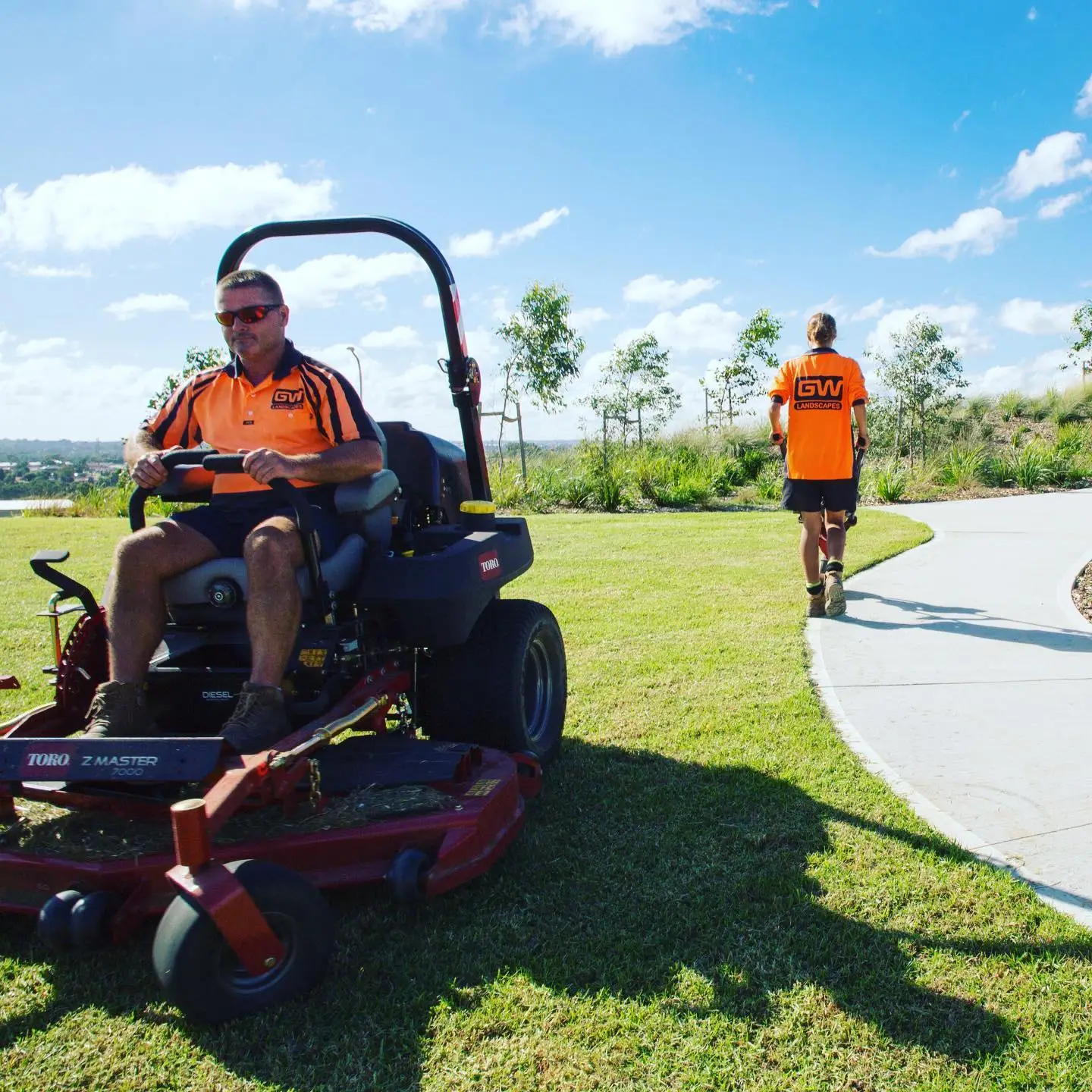 A photo of two Greater West Landscapes Maintenance workers on a sunny day.